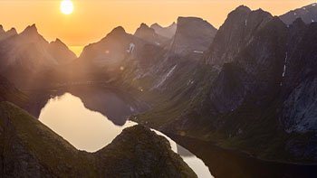 midnight-sun-casts-hazy-glow-reinebringen-with-steep-peaks-framing-still-waters-creating-stunning-contrast-heart-lofoten-islands