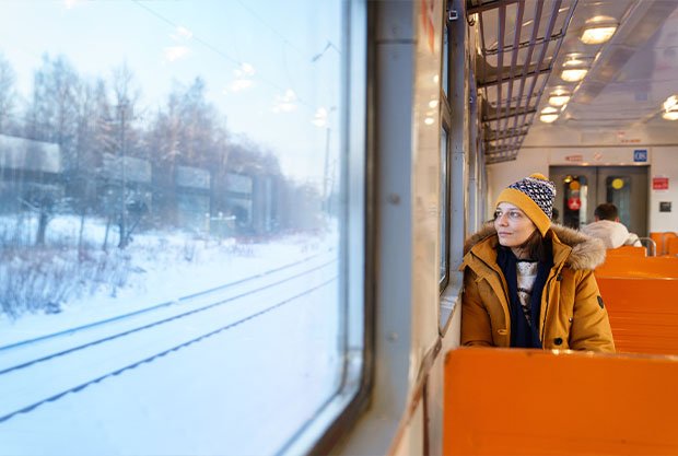 pensive-girl-traveling-by-local-train-winter-time-looking-through-window-snowy-landscape