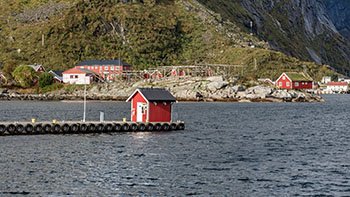 red-cabin-end-pier-foot-norwegian-village-mountain-clouds-island-moskenesoya-archipelago-lofoten